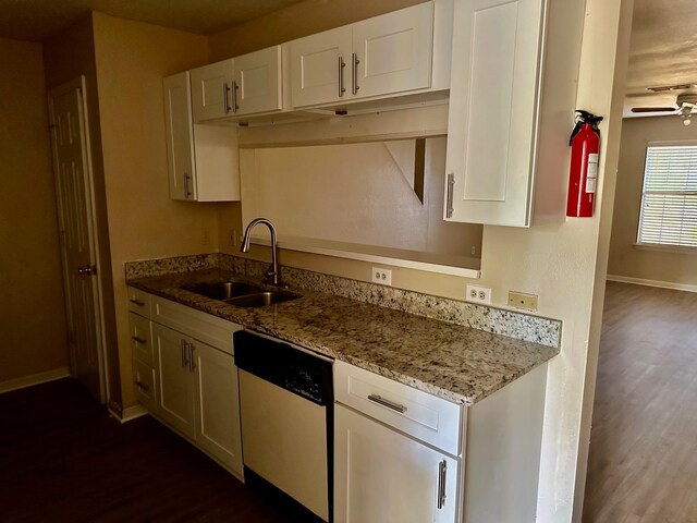 kitchen with dark wood-type flooring, light stone counters, dishwasher, white cabinets, and sink