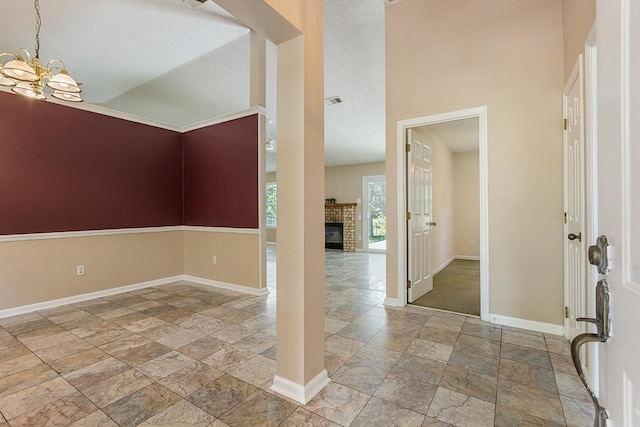 2304 Chester Ct, Tallahassee, FL 32312 - entryway with a chandelier, a brick fireplace, stone tile floors, and baseboards