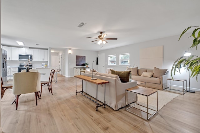 living room featuring light hardwood / wood-style flooring and ceiling fan