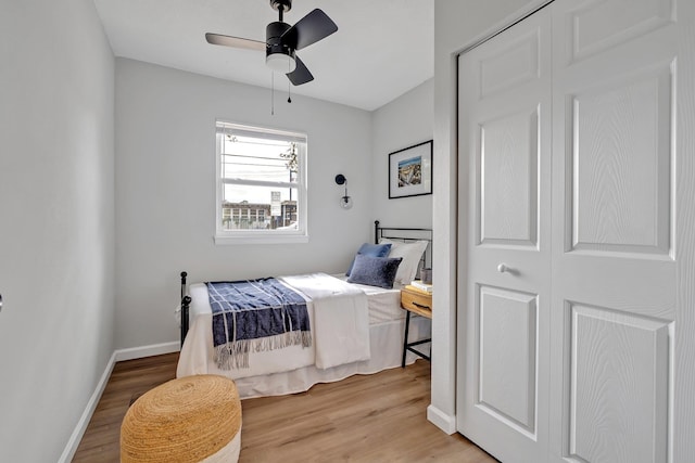 bedroom with ceiling fan, light hardwood / wood-style flooring, and a closet