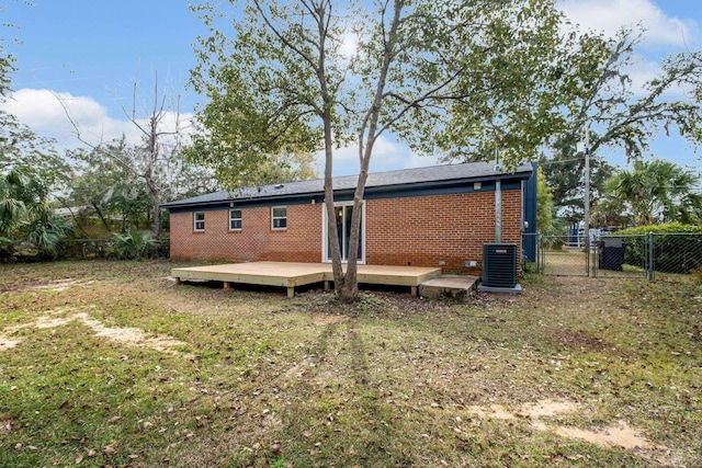 rear view of house with a deck, a lawn, and central AC