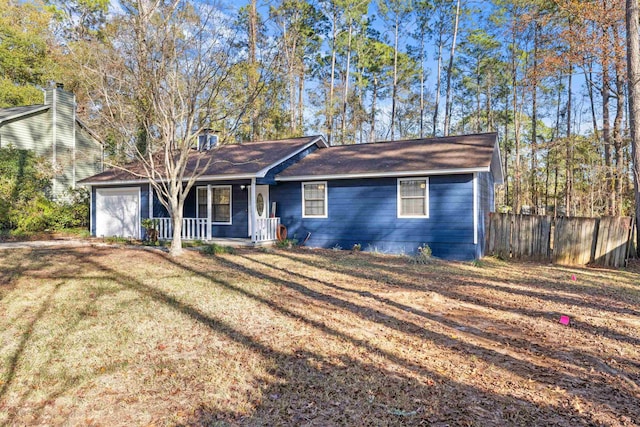 ranch-style house with covered porch, a front yard, and a garage