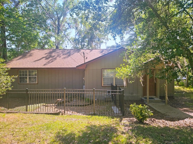 view of front of home featuring fence and roof with shingles