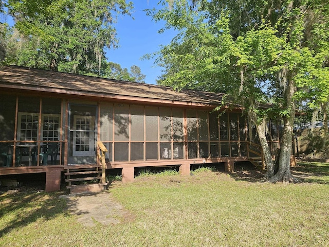 back of property with a yard and a sunroom