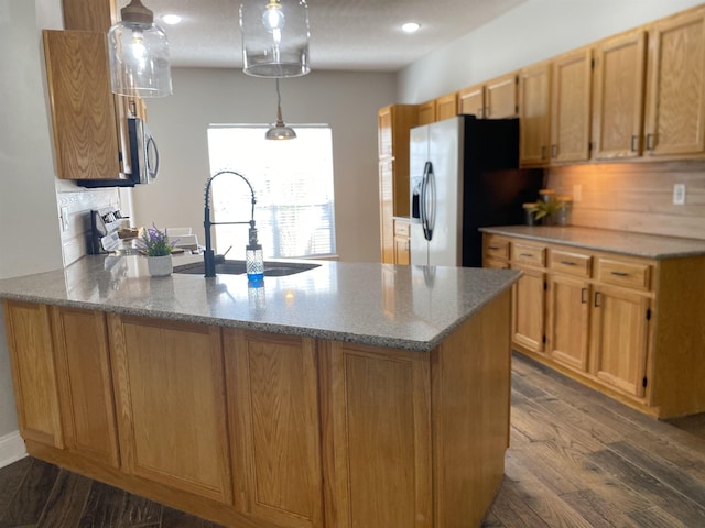 kitchen with appliances with stainless steel finishes, sink, dark hardwood / wood-style flooring, hanging light fixtures, and kitchen peninsula