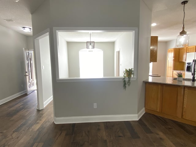 kitchen featuring pendant lighting, dark hardwood / wood-style flooring, and stainless steel fridge with ice dispenser