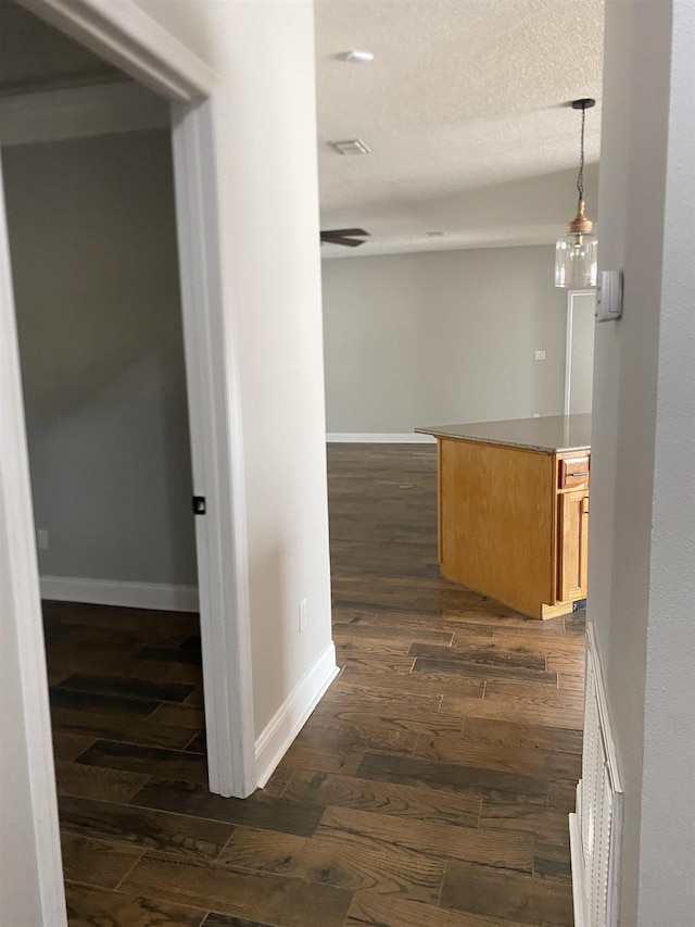 hallway with dark hardwood / wood-style floors and a textured ceiling