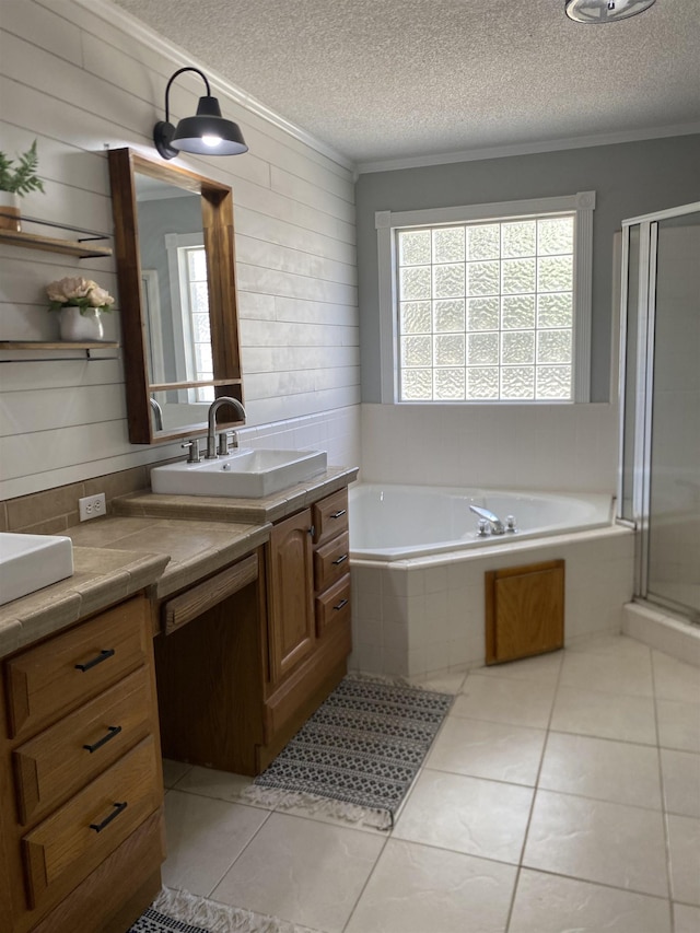 bathroom with tile patterned floors, vanity, shower with separate bathtub, and a textured ceiling