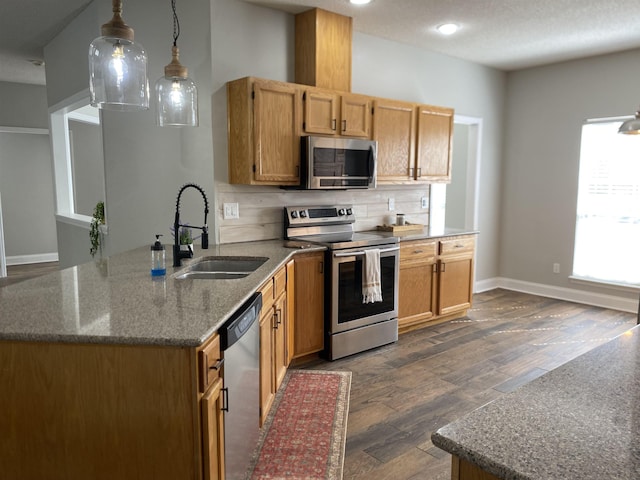 kitchen with stone counters, pendant lighting, sink, dark hardwood / wood-style flooring, and stainless steel appliances