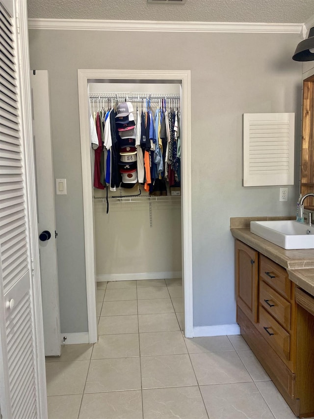 bathroom with tile patterned floors, vanity, and ornamental molding