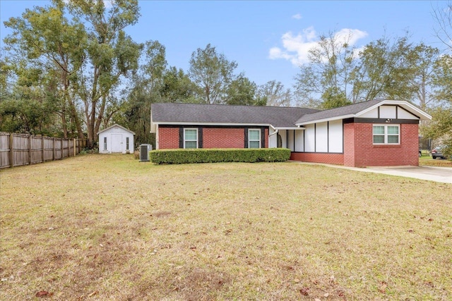 view of front of property featuring a shed, an outdoor structure, fence, and a front yard