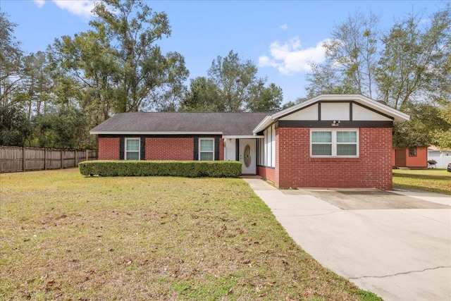 ranch-style house featuring a front yard, concrete driveway, brick siding, and fence