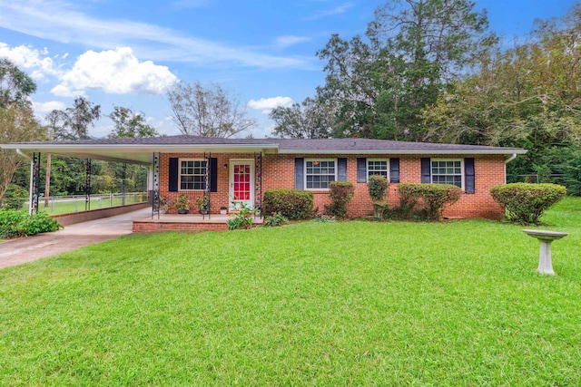 single story home featuring brick siding, a carport, a front lawn, and driveway