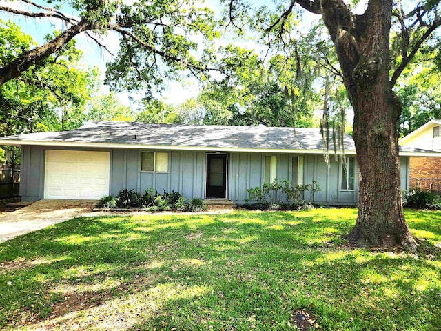 single story home with board and batten siding, an attached garage, a front yard, and concrete driveway