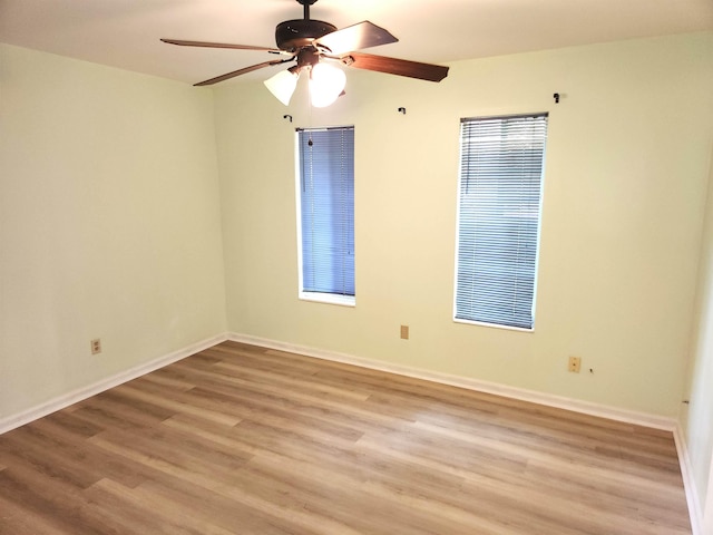 empty room featuring light wood-type flooring, baseboards, and ceiling fan