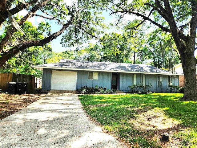 single story home featuring a front lawn, driveway, board and batten siding, fence, and a garage