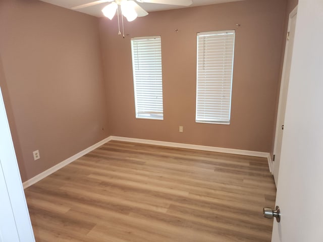 spare room with a ceiling fan, baseboards, and light wood-style floors