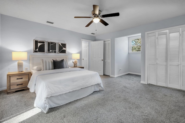 bedroom featuring ceiling fan, two closets, and carpet floors