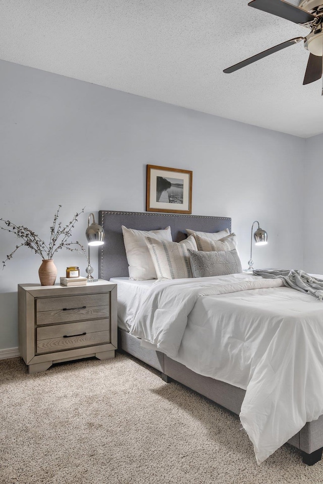 bedroom with a textured ceiling, ceiling fan, and light colored carpet