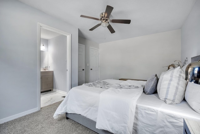 bedroom featuring ceiling fan, ensuite bathroom, and light colored carpet