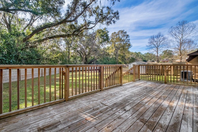 wooden terrace featuring central AC unit and a yard