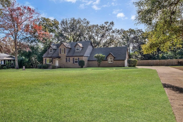 cape cod home with a front lawn