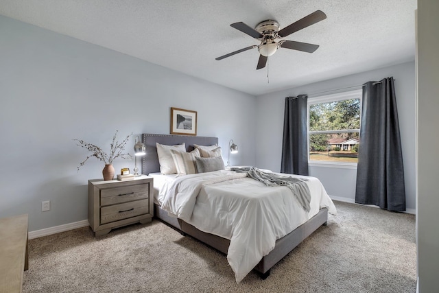 carpeted bedroom featuring ceiling fan and a textured ceiling