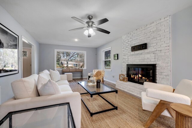 living room with ceiling fan, a fireplace, and hardwood / wood-style floors