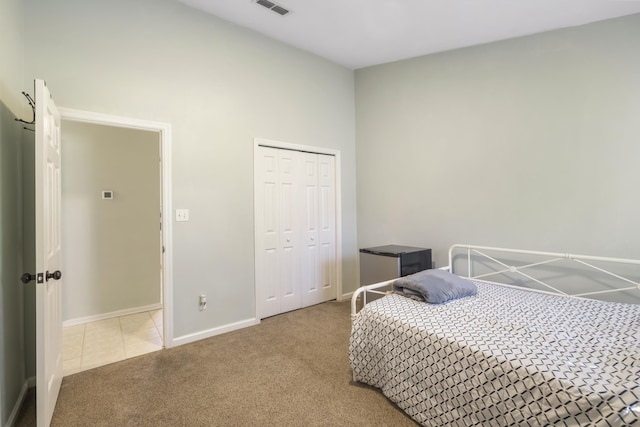 bedroom featuring visible vents, baseboards, tile patterned floors, carpet, and a closet