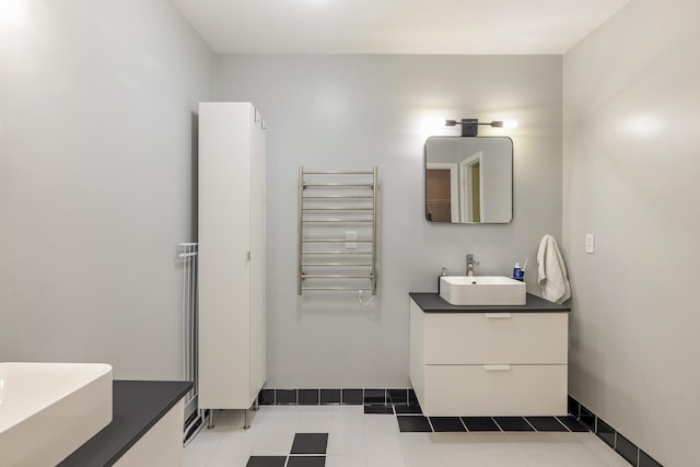 bathroom with radiator, vanity, and baseboards