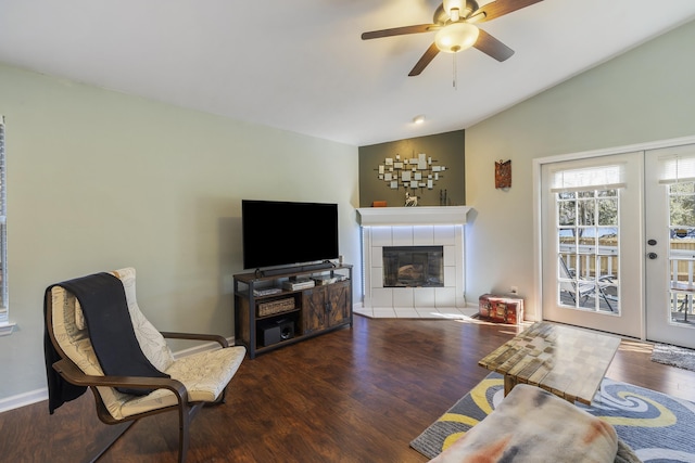 living room with french doors, a fireplace, lofted ceiling, a ceiling fan, and wood finished floors