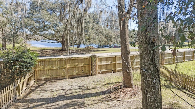 view of yard featuring a water view and a fenced backyard