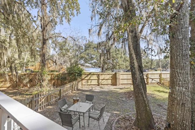 view of yard featuring a patio area, a fenced backyard, and outdoor dining space