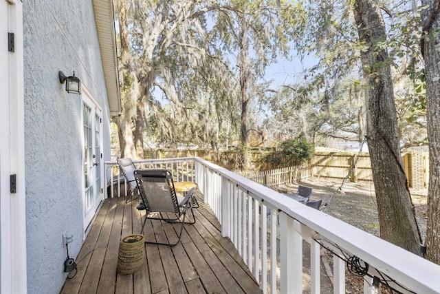 wooden terrace with a fenced backyard