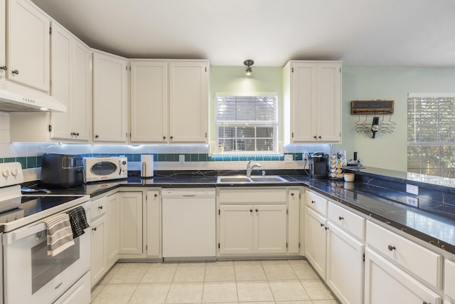 kitchen with white appliances, a sink, white cabinetry, and decorative backsplash