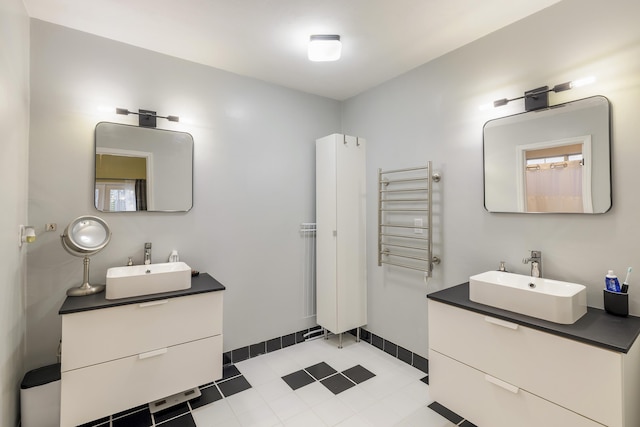 bathroom with radiator heating unit, two vanities, and a sink