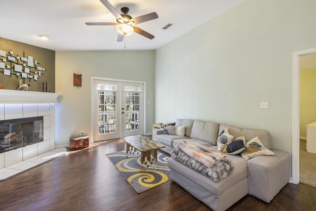 living area featuring lofted ceiling, visible vents, wood finished floors, and french doors