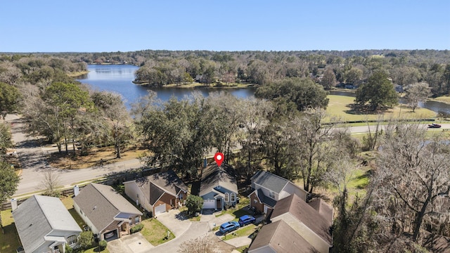 drone / aerial view featuring a water view, a forest view, and a residential view