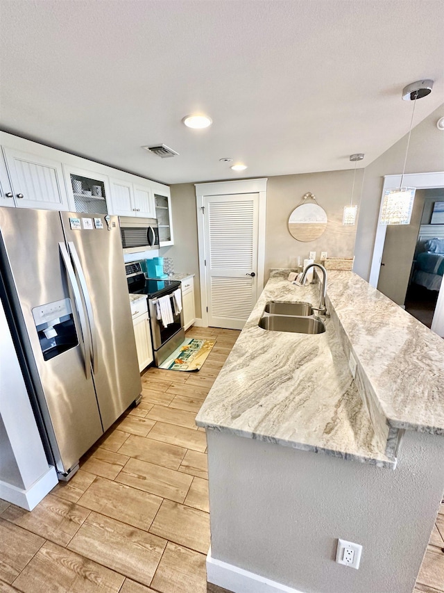 9100 Baytowne Wharf Boulevard 470/472, Walton Beaches, FL 32550 - kitchen with a sink, appliances with stainless steel finishes, wood tiled floors, white cabinets, and glass insert cabinets