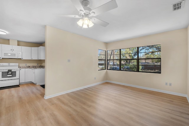 kitchen featuring white appliances, visible vents, white cabinets, baseboards, and light wood finished floors