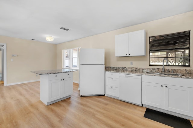 kitchen featuring light wood finished floors, white appliances, a sink, and visible vents