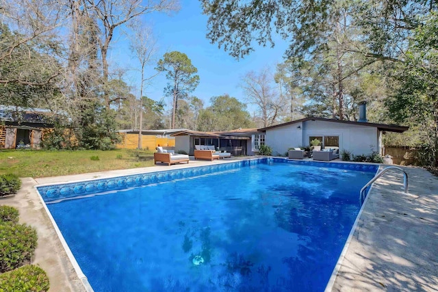 outdoor pool with a yard, fence, and an outdoor hangout area