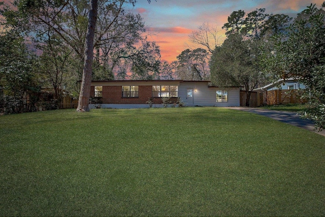 view of front facade with fence and a lawn