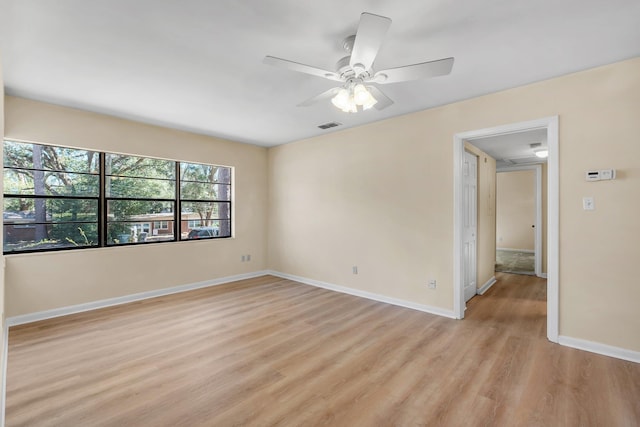 unfurnished room featuring a ceiling fan, light wood-type flooring, visible vents, and baseboards