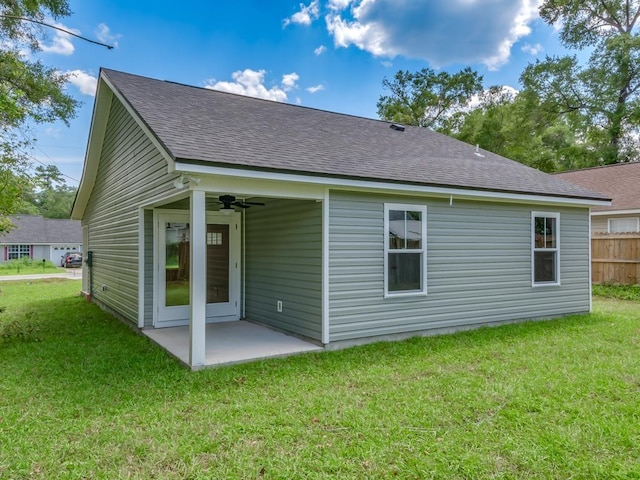 rear view of property featuring ceiling fan, a yard, and a patio