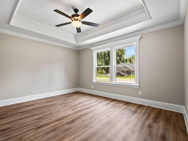 unfurnished room featuring ceiling fan, ornamental molding, hardwood / wood-style flooring, and a tray ceiling