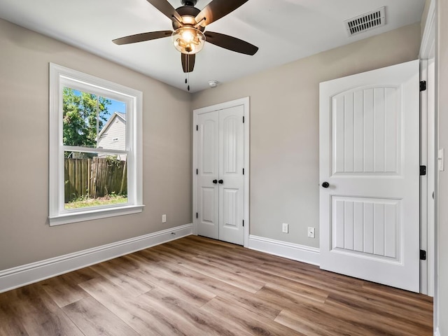 unfurnished bedroom with ceiling fan, a closet, and light hardwood / wood-style flooring