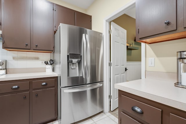 4557 Running Meadows Ln, Tallahassee, FL 32303 - kitchen with stainless steel fridge, light countertops, wainscoting, backsplash, and dark brown cabinets