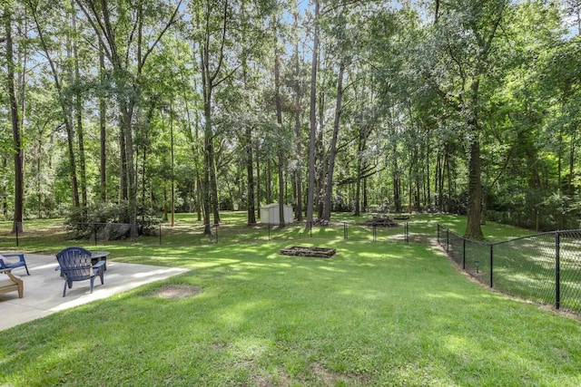 4557 Running Meadows Ln, Tallahassee, FL 32303 - fenced backyard with a fire pit, a patio, and a storage unit