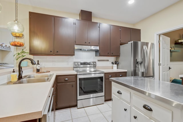 4557 Running Meadows Ln, Tallahassee, FL 32303 - kitchen with stainless steel appliances, under cabinet range hood, stainless steel counters, light tile patterned floors, and decorative backsplash